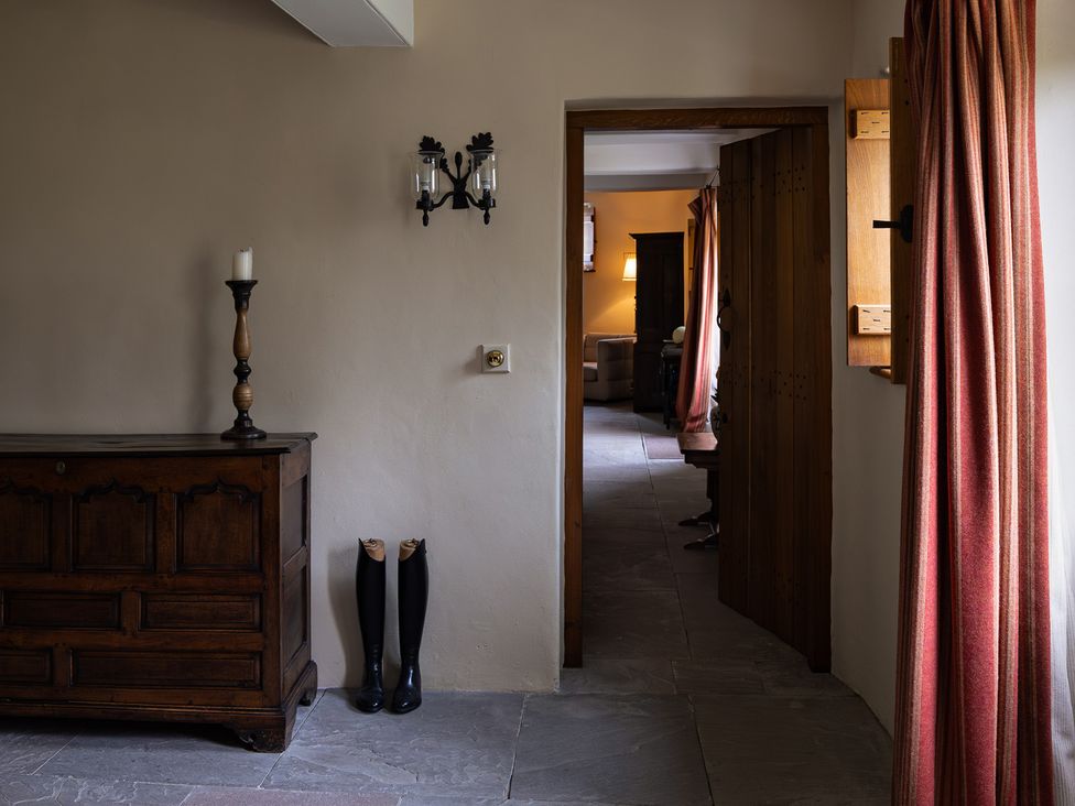A hallway with a wooden chest and candle holder at West Cottage Myddfai near Llandovery
