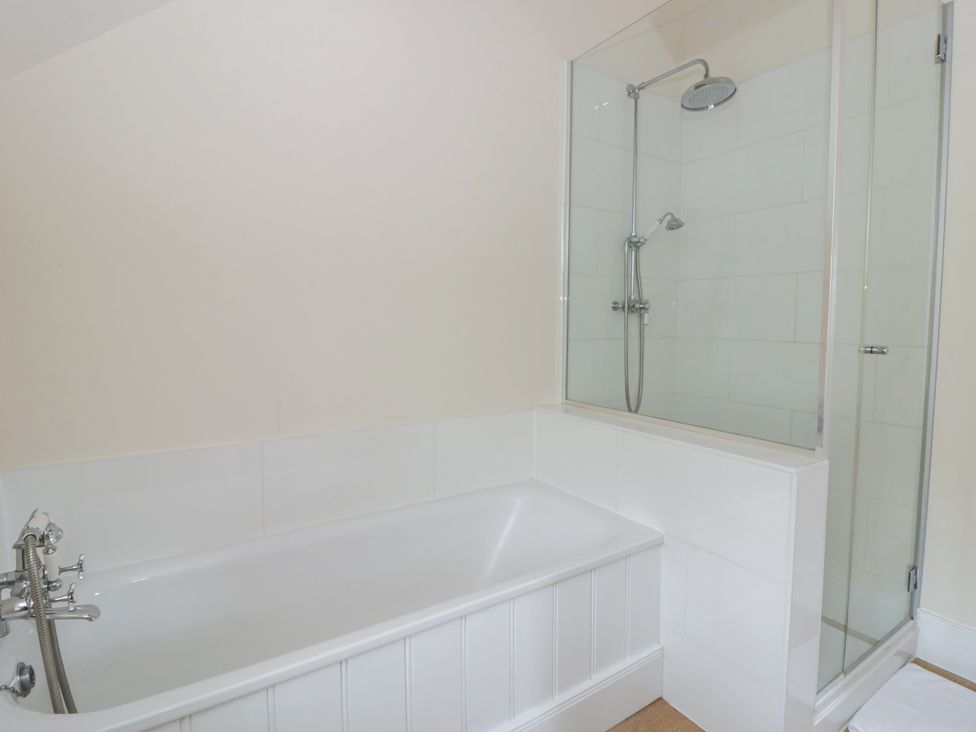 A bathroom with a bathtub and a shower at Gatekeepers Cottage Myddfai near Llandovery