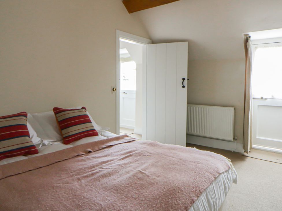 A bedroom with a bed and curtains at Gatekeepers Cottage in Myddfai near Llandovery