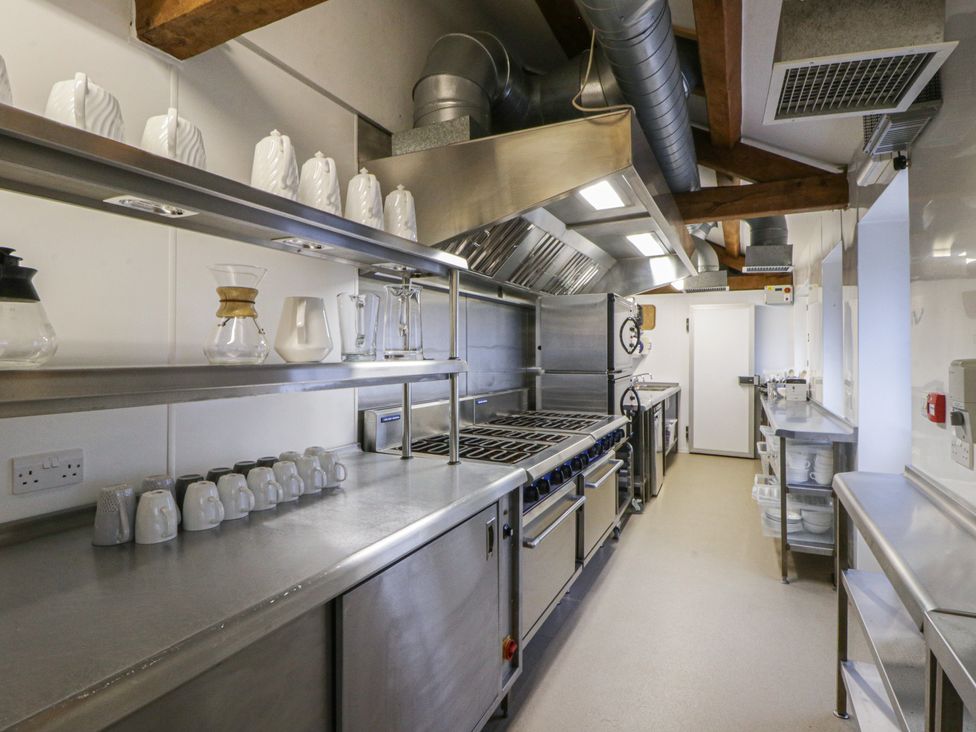 A kitchen with stainless steel appliances and shelves at Gatekeepers Cottage in Myddfai near Llandovery