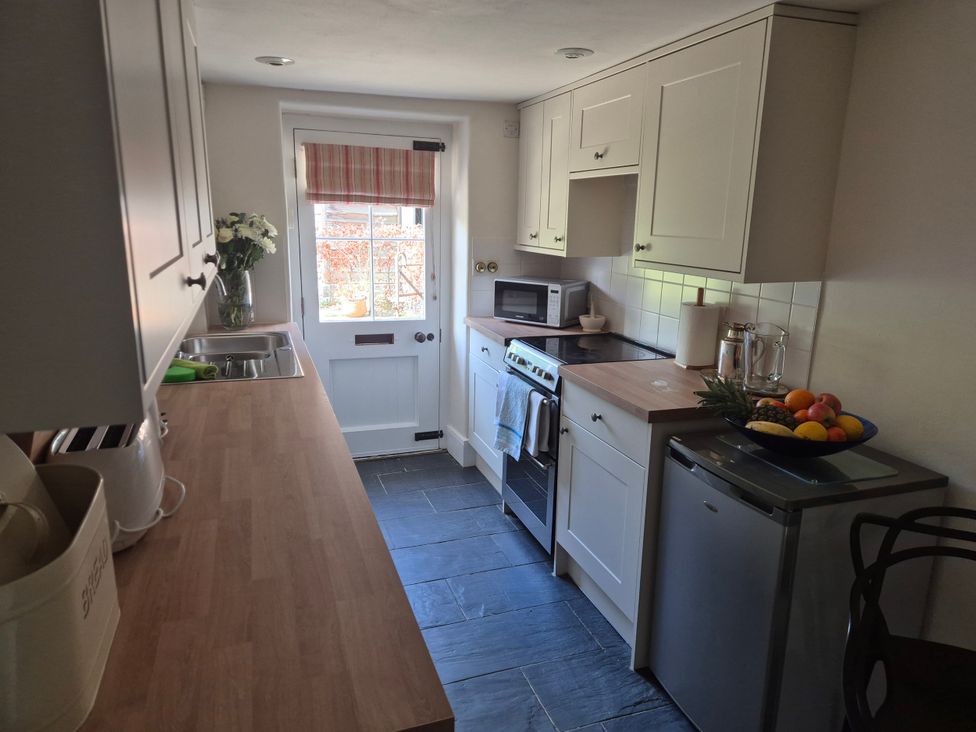 A kitchen with cabinets and appliances at Gatekeepers Cottage Myddfai near Llandovery