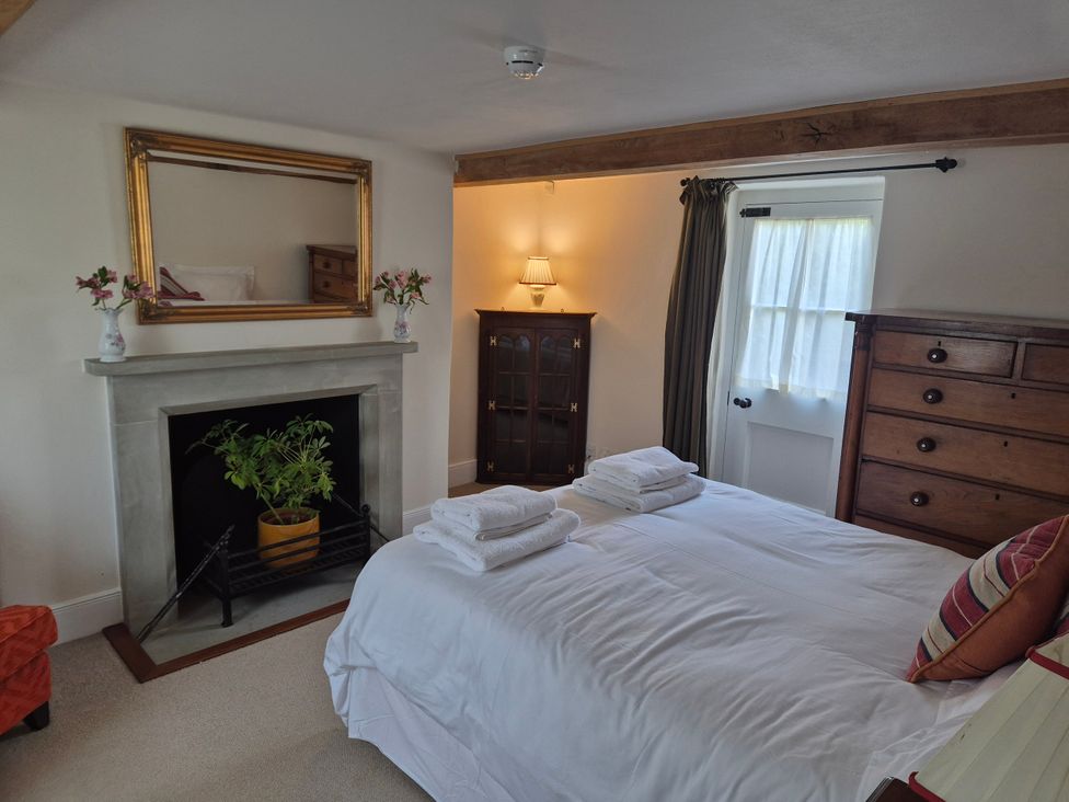 A bedroom with a bed and a fireplace at Gatekeepers Cottage Myddfai near Llandovery