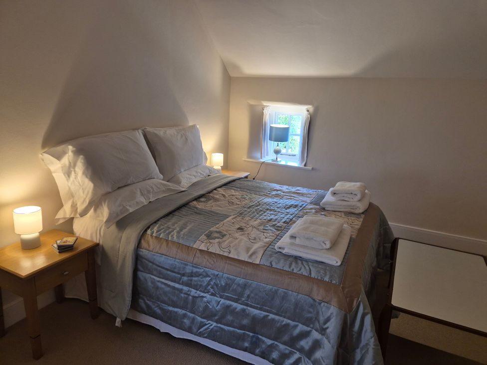 A bedroom with a bed and bedside table at Gatekeepers Cottage in Myddfai near Llandovery