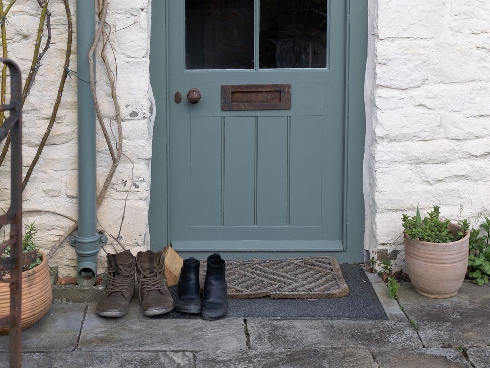 An entryway with boots and a door at Gatekeepers Cottage in Myddfai near Llandovery