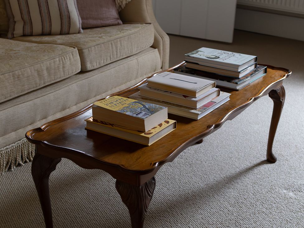 A coffee table with books on top at Gatekeepers Cottage near Llandovery