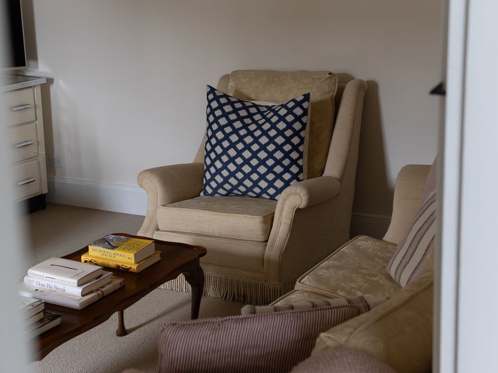 A living room with an armchair and a coffee table at Gatekeepers Cottage Myddfai near Llandovery