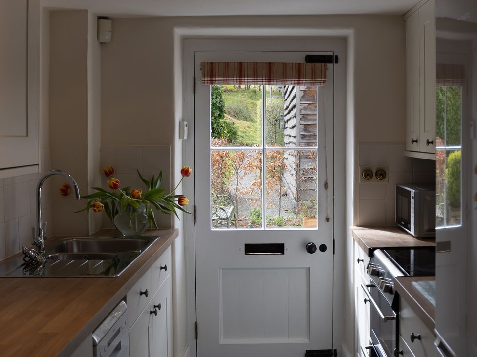 A kitchen with a sink and door leading outside at Gatekeepers Cottage Myddfai near Llandovery