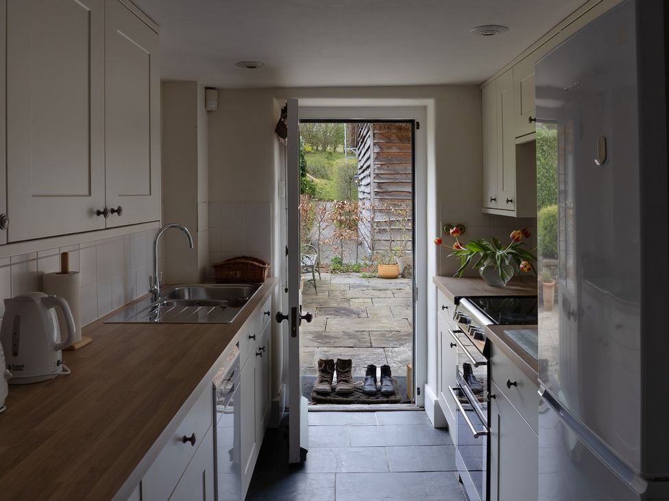 A kitchen with a sink and door leading to outdoor area at Gatekeepers Cottage in Myddfai near Llandovery