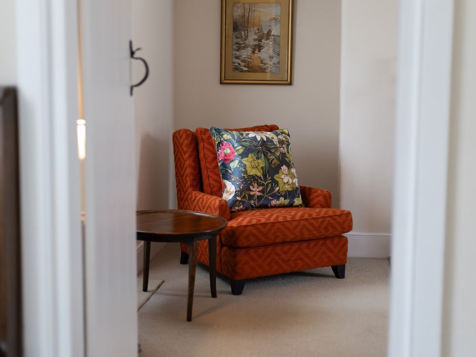 A sitting room with an armchair and a side table at Gatekeepers Cottage near Myddfai Llandovery