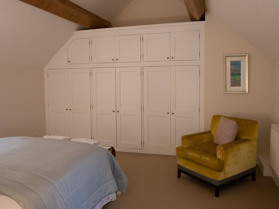 A bedroom with a bed and a wardrobe at Gatekeepers Cottage Myddfai near Llandovery