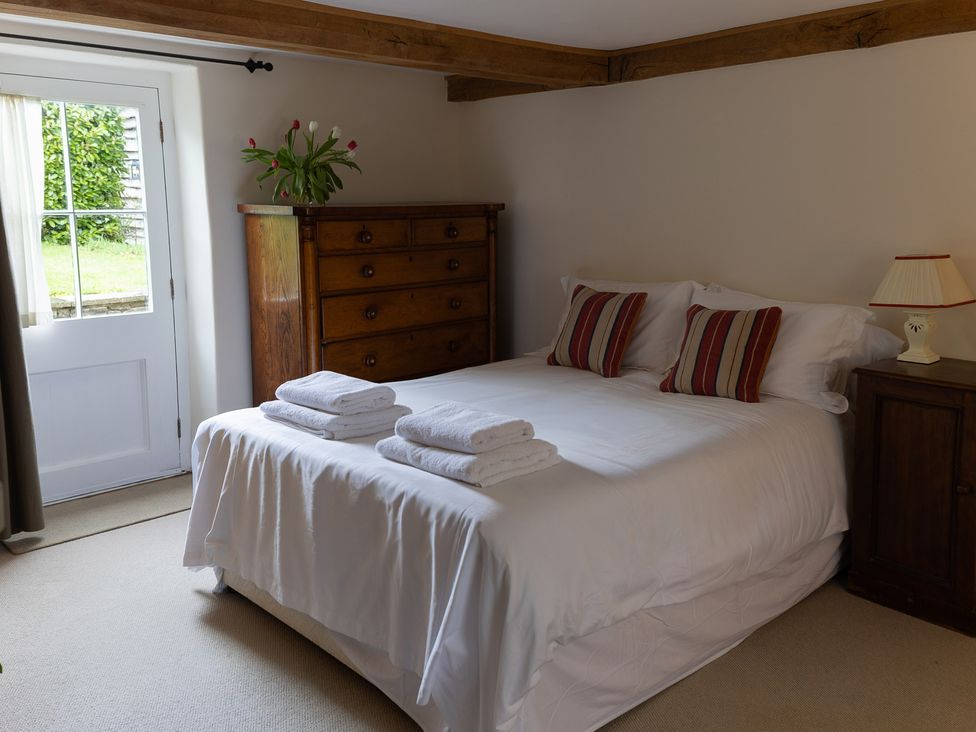 A bedroom with a bed and dresser at Gatekeepers Cottage in Myddfai near Llandovery