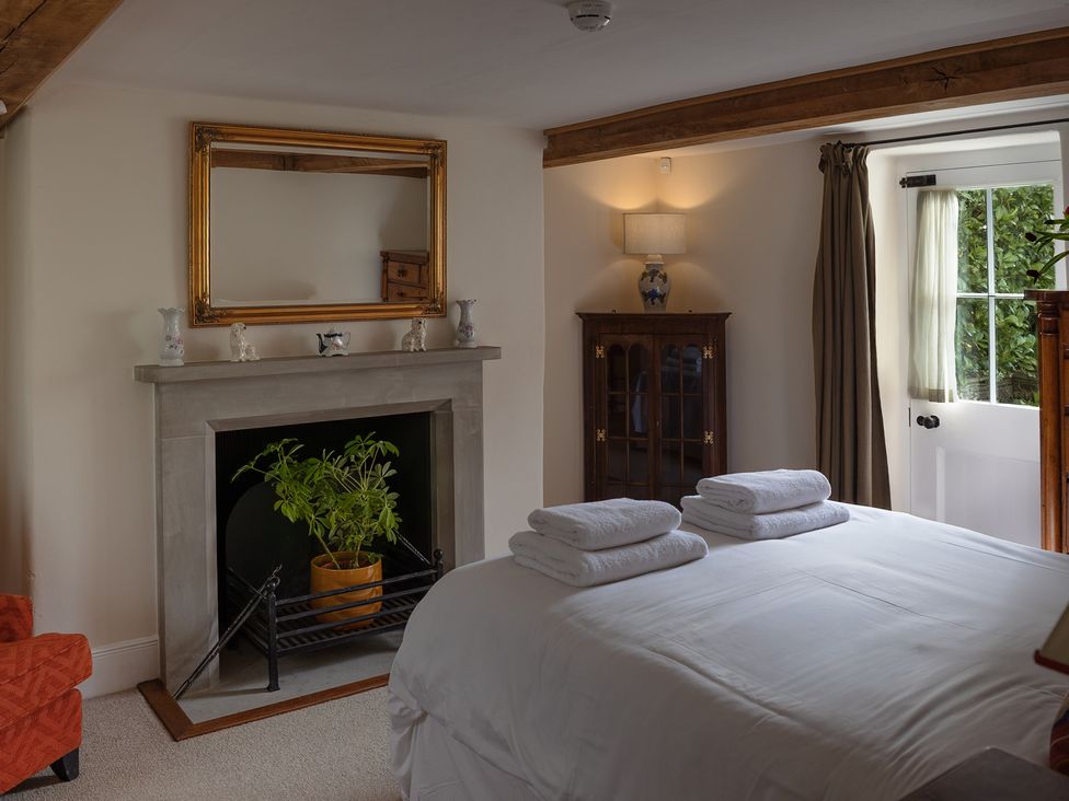 A bedroom with a bed and fireplace at Gatekeepers Cottage Myddfai near Llandovery