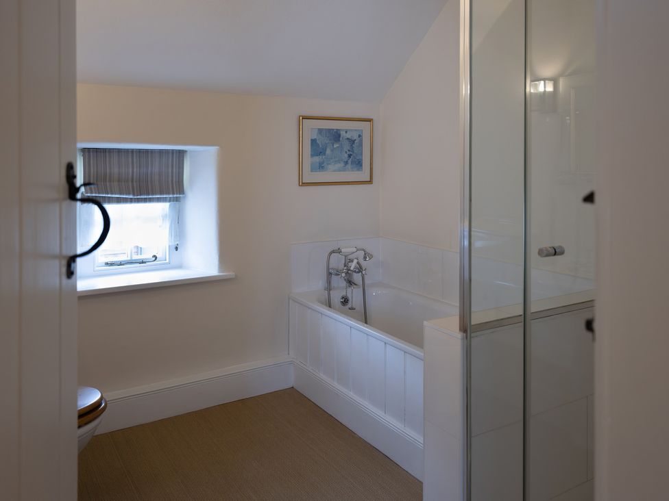 A bathroom with a bathtub and shower at Gatekeepers Cottage in Myddfai near Llandovery