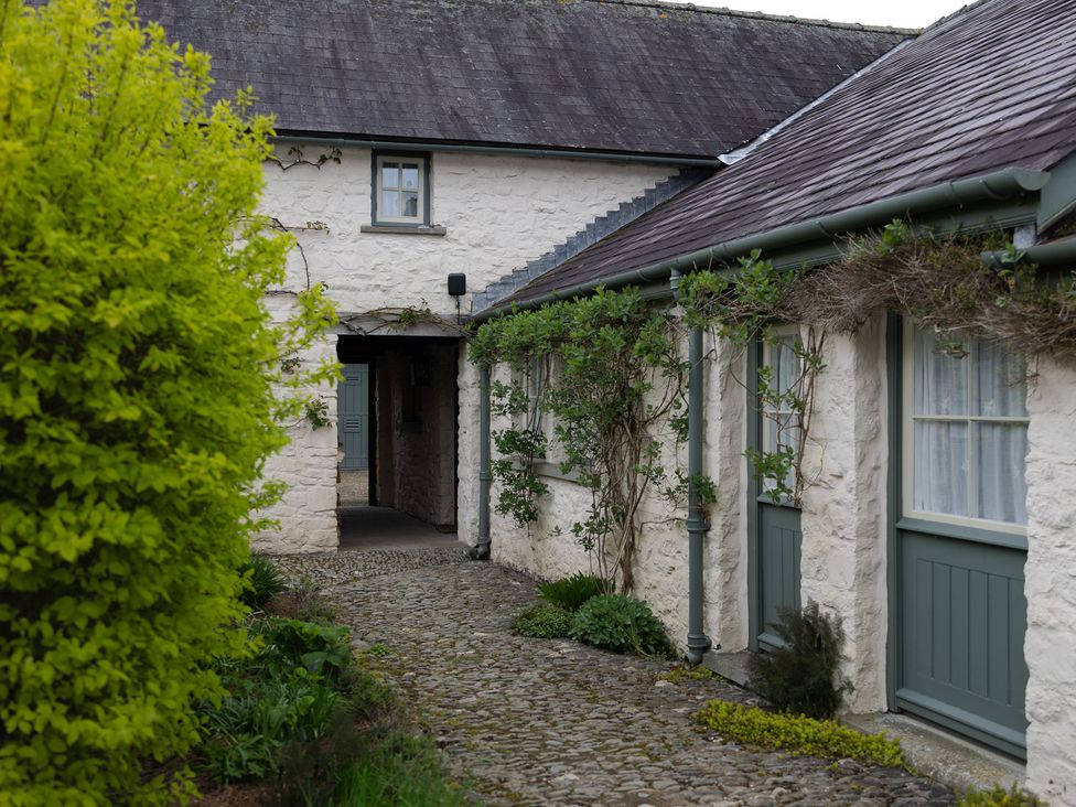 An outdoor area with stone walls and greenery at Gatekeepers Cottage in Myddfai near Llandovery