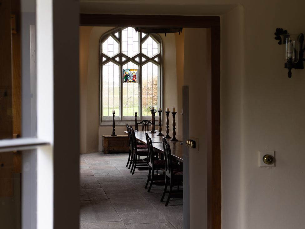 A dining room with a long table and chairs at Gatekeepers Cottage in Myddfai near Llandovery