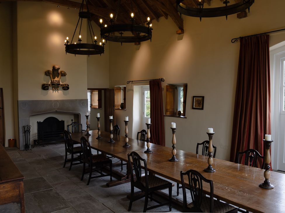 A dining room with a long table and chairs at Gatekeepers Cottage Myddfai near Llandovery