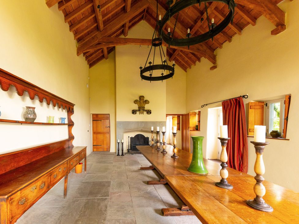 A dining room with a long table and candlesticks at North Cottage in Llandovery