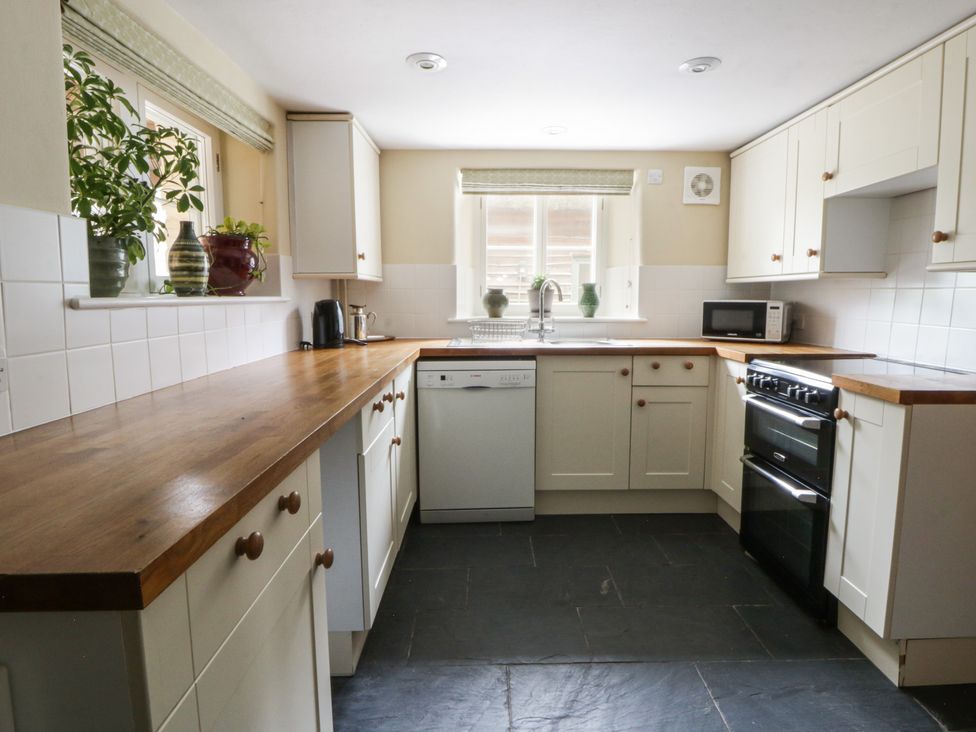 A kitchen with wooden counter and appliances at North Cottage in Llandovery