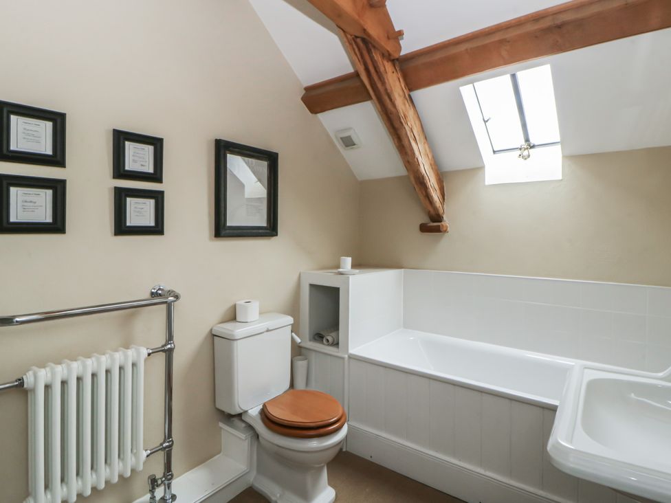A bathroom with a bathtub, toilet, and sink at North Cottage in Llandovery