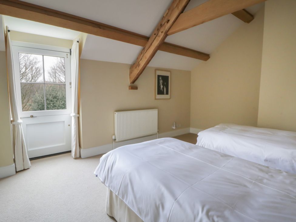 A bedroom with two beds and a window at North Cottage in Llandovery