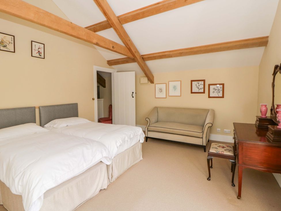 A bedroom with two beds and a sofa at North Cottage in Myddfai near Llandovery