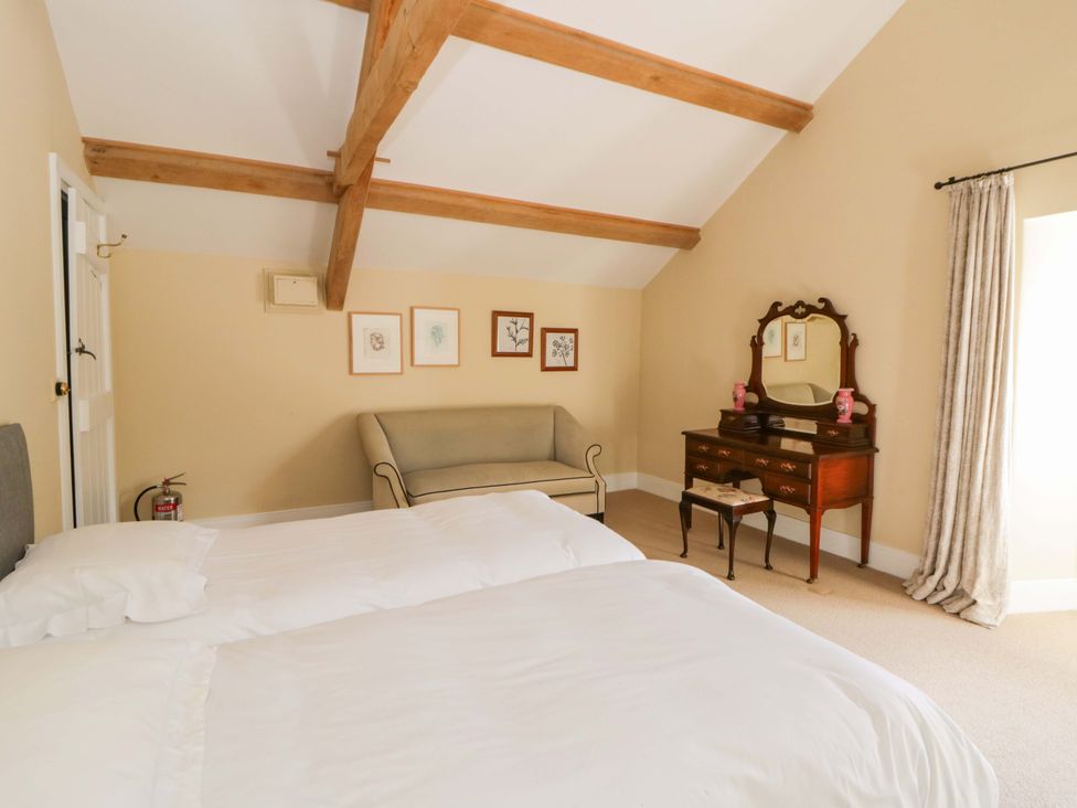 A bedroom with two beds and a dresser at North Cottage in Myddfai near Llandovery