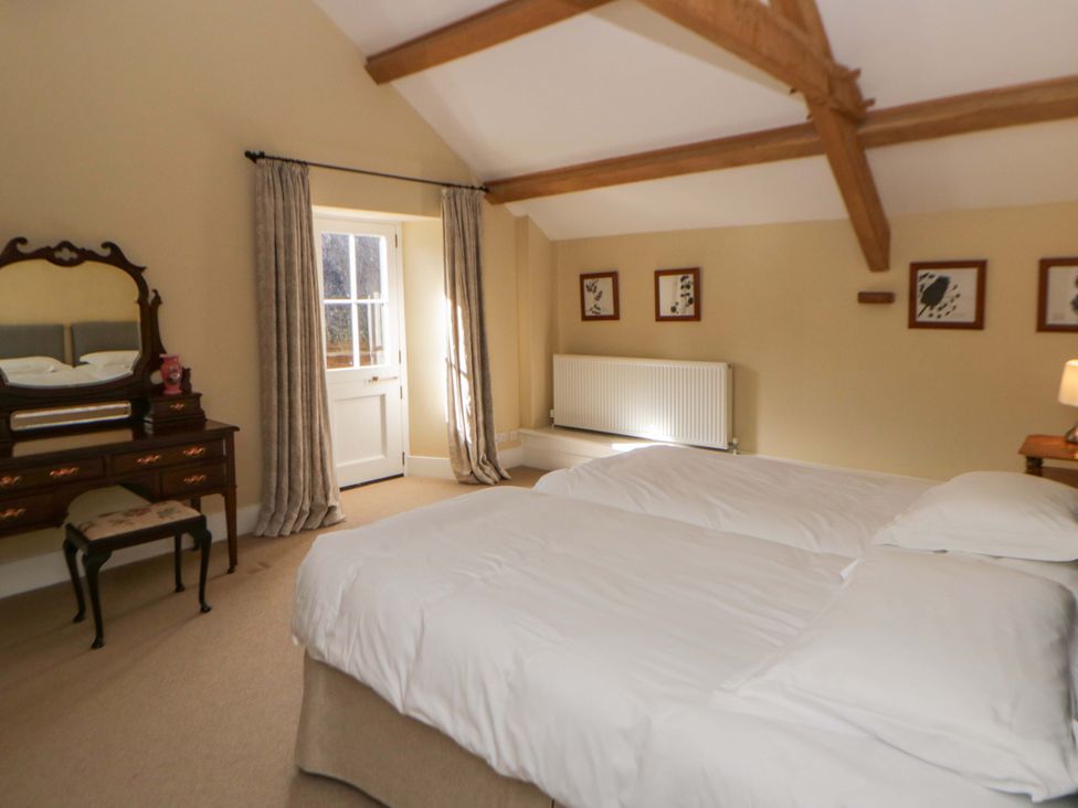 A bedroom with two beds and a mirror at North Cottage Myddfai near Llandovery