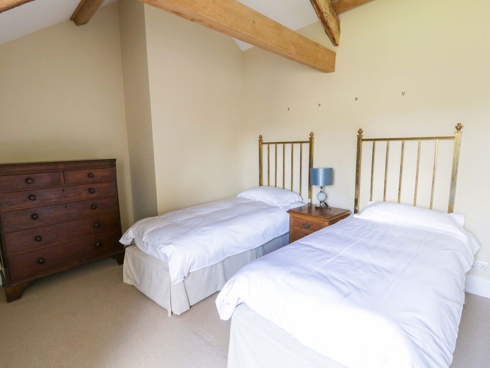 A bedroom with two beds and a dresser at North Cottage Myddfai near Llandovery