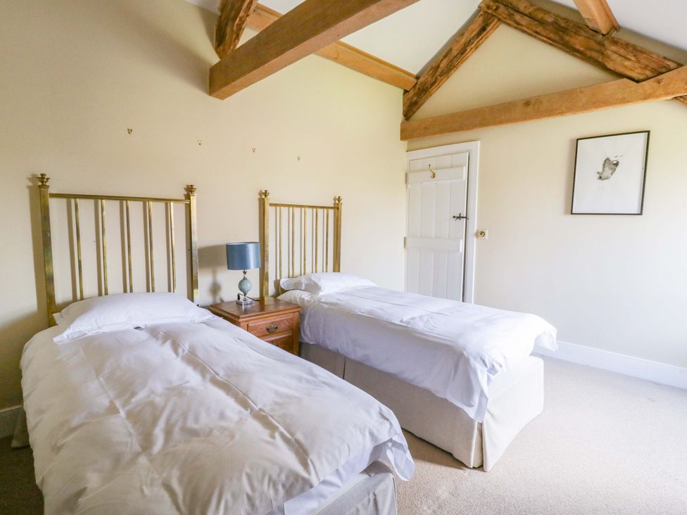 A bedroom with two beds and a nightstand at North Cottage Myddfai near Llandovery