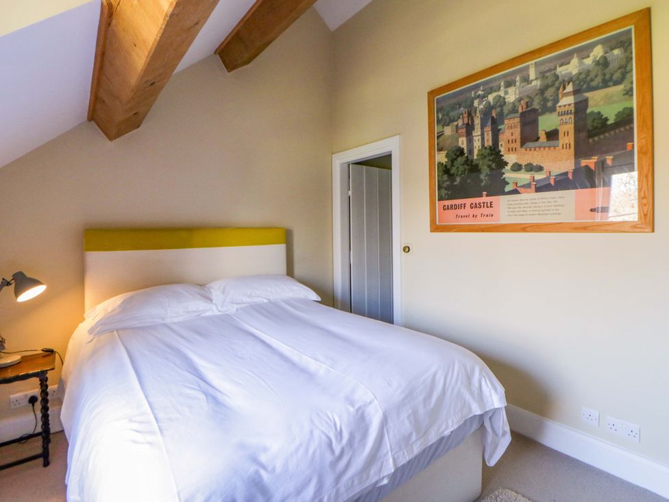 A bedroom with a bed and a painting at North Cottage in Myddfai near Llandovery