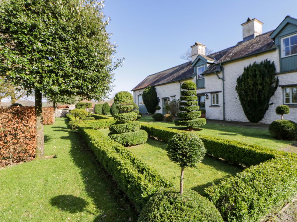 A garden with trimmed hedges and trees at North Cottage in Myddfai near Llandovery