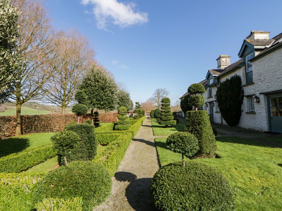 A garden with a pathway and topiary at North Cottage Myddfai near Llandovery