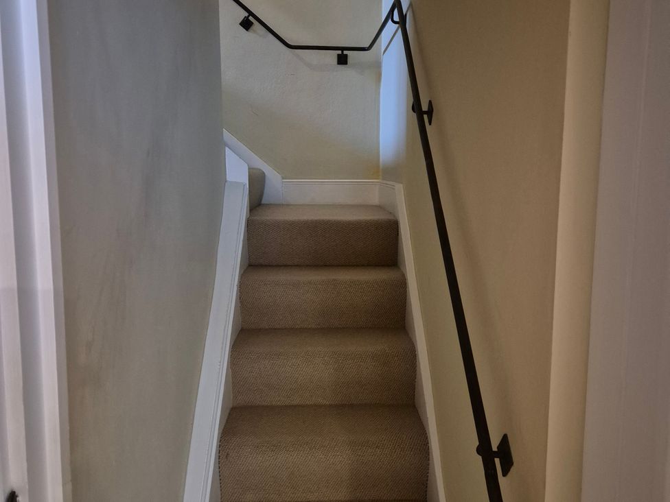 A staircase with carpet and handrail at North Cottage Myddfai near Llandovery