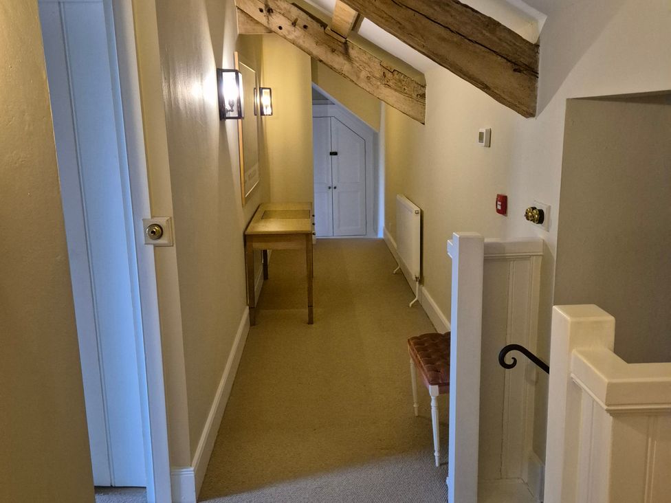 A hallway with a table and a door at North Cottage in Myddfai near Llandovery