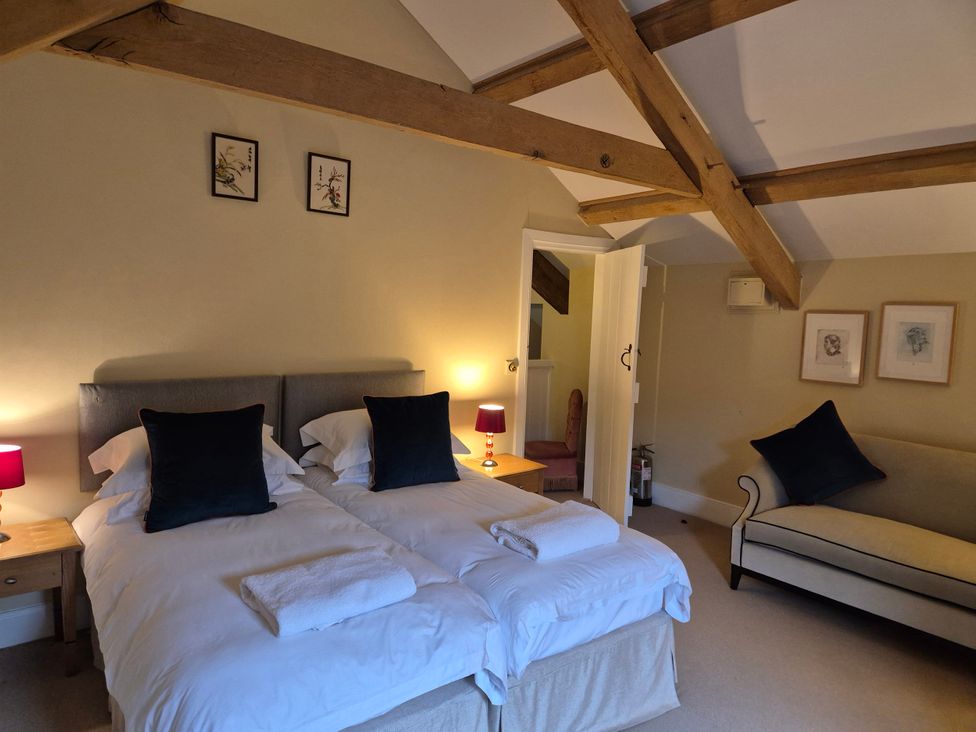 A bedroom with two single beds and a sofa at North Cottage Myddfai near Llandovery