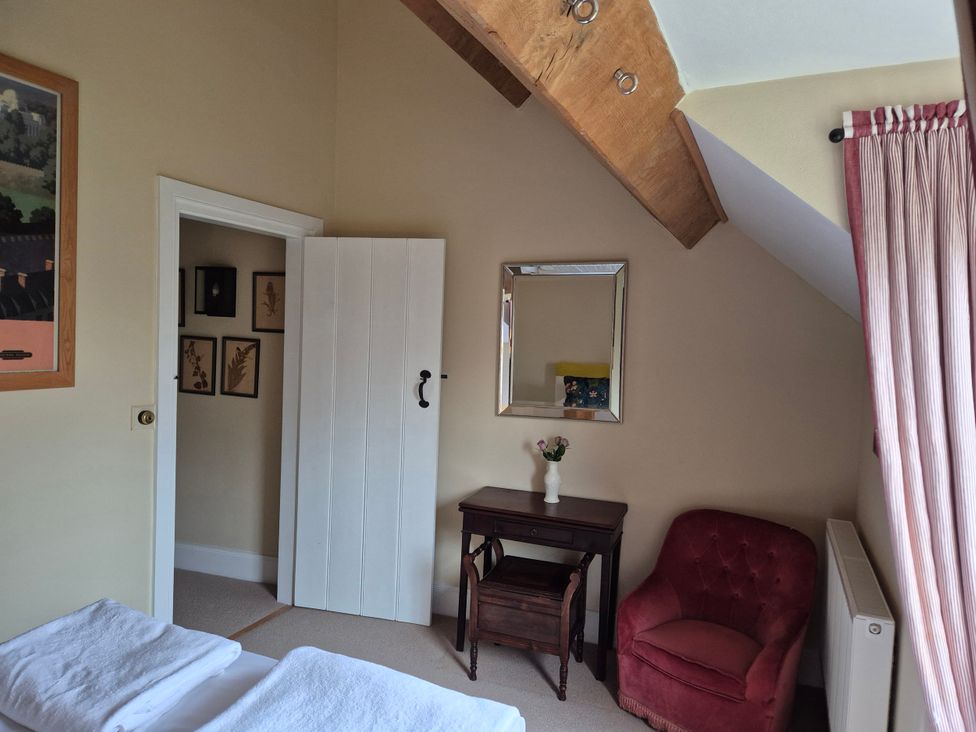 A bedroom with a chair and table at North Cottage Myddfai near Llandovery