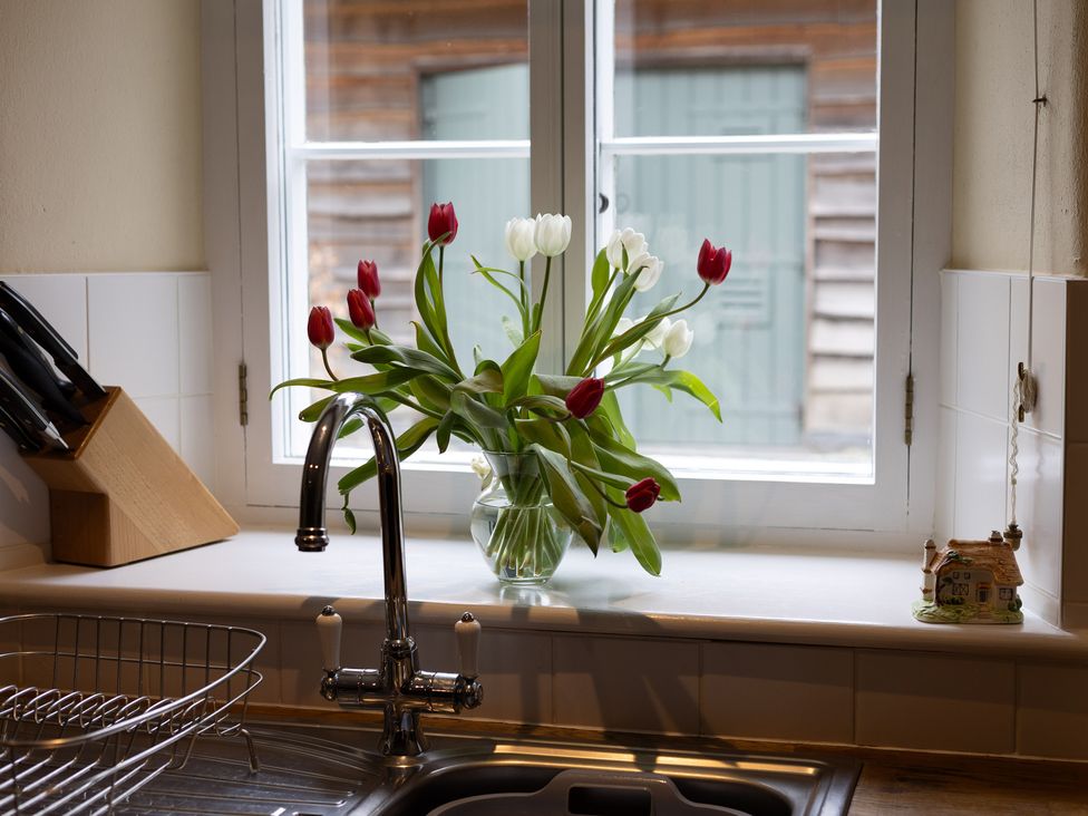 A kitchen with a sink and a vase of flowers at North Cottage in Myddfai near Llandovery