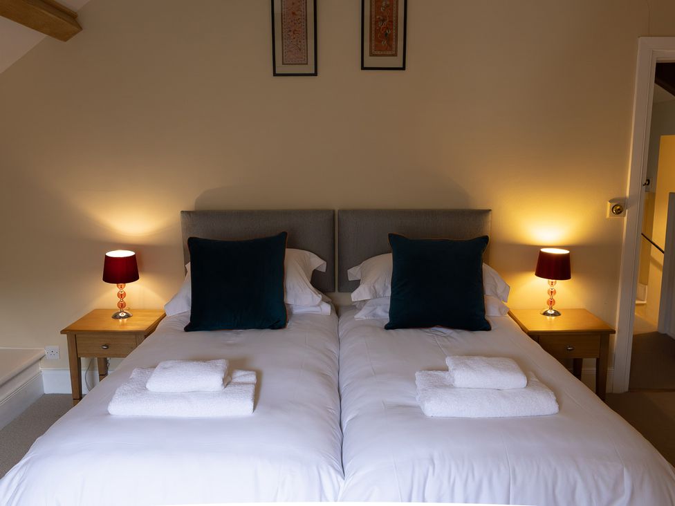 A bedroom with two beds and lamps at North Cottage in Myddfai near Llandovery