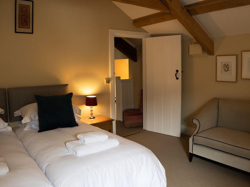 A bedroom with two beds and a sofa at North Cottage in Myddfai near Llandovery