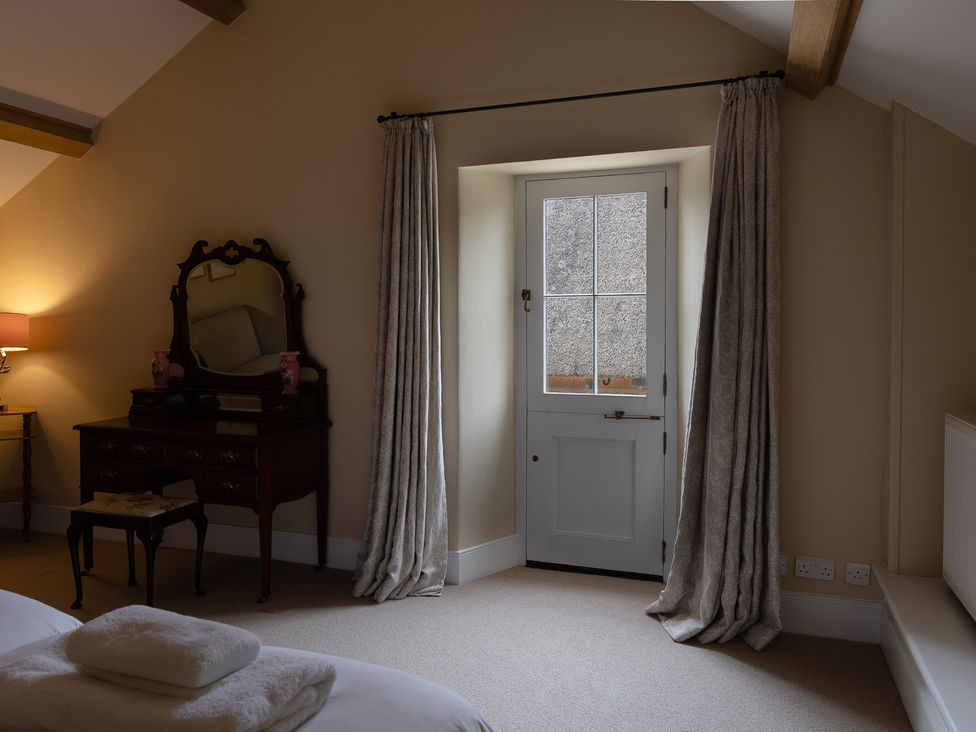 A bedroom with a mirror and a lamp at North Cottage in Myddfai near Llandovery