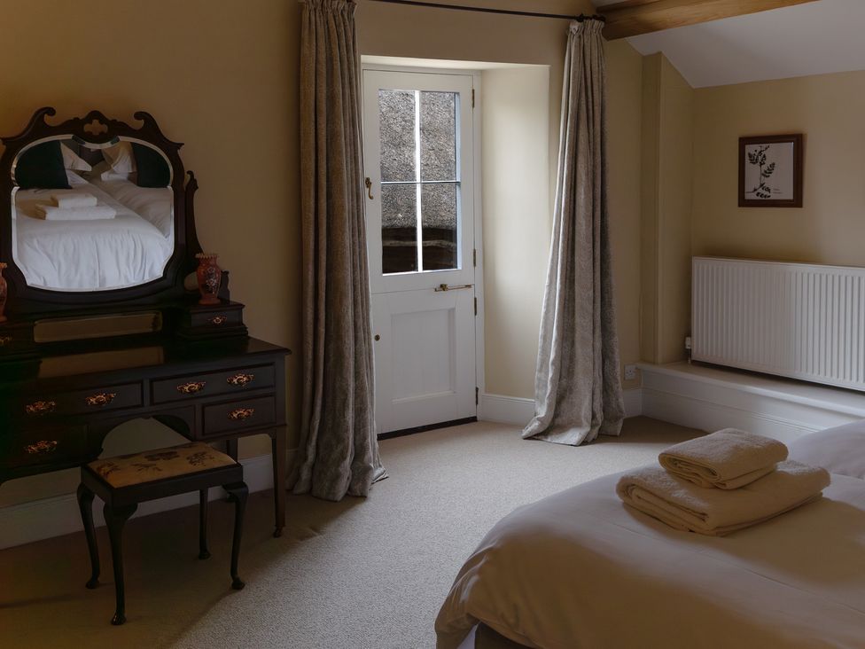 A bedroom with a bed and mirror at North Cottage in Myddfai near Llandovery