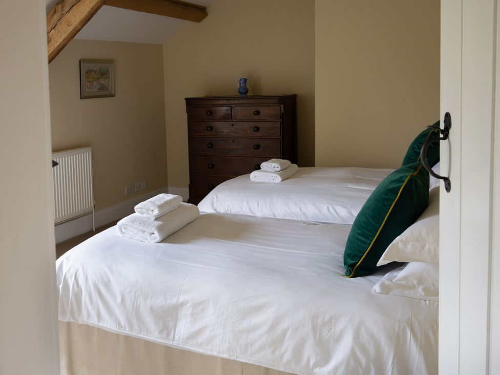 A bedroom with two beds and a wooden dresser at North Cottage Myddfai near Llandovery