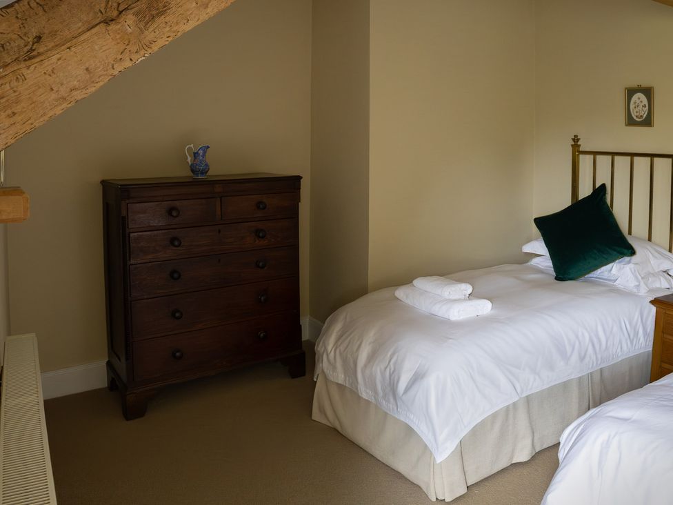 A bedroom with a bed, dresser and towels at North Cottage Myddfai near Llandovery