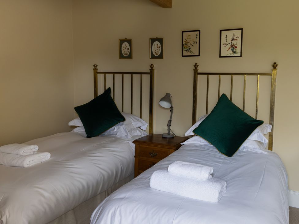 A bedroom with twin beds and a bedside table with a lamp at North Cottage in Myddfai near Llandovery