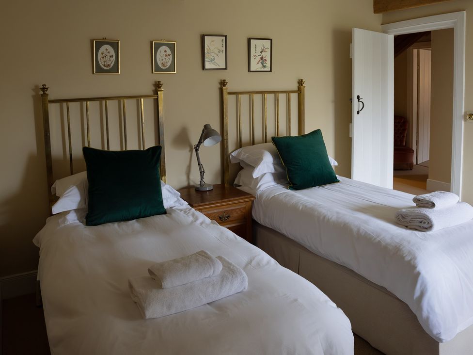 A bedroom with two beds and wall art at North Cottage Myddfai near Llandovery