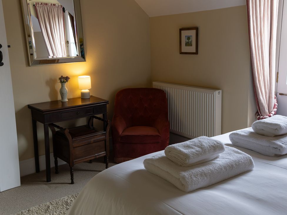 A bedroom with a bed and a lamp on a table at North Cottage near Llandovery