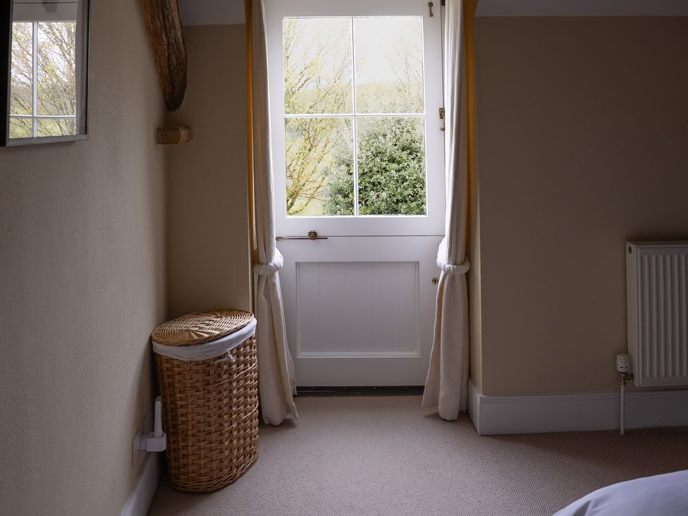 A bedroom with a window and door at North Cottage Myddfai near Llandovery