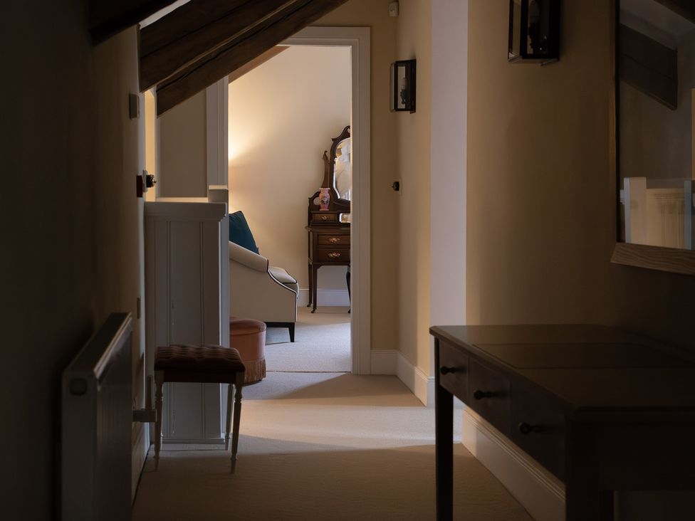 A hallway with a dressing table and armchair at North Cottage Myddfai near Llandovery