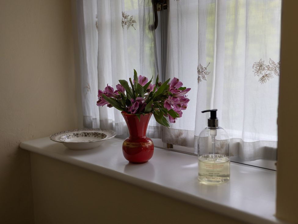 A flower vase with flowers on a windowsill at North Cottage Myddfai near Llandovery
