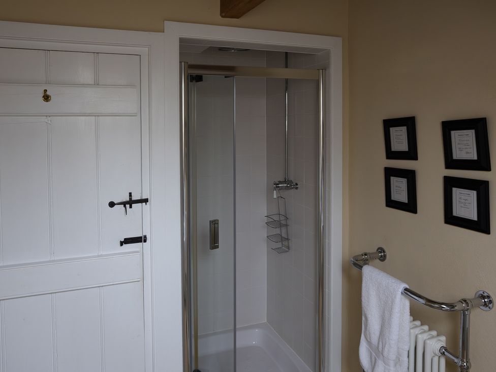 A bathroom with a shower and towel rack at North Cottage in Myddfai near Llandovery